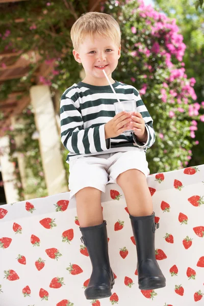 Junge in Gummistiefeln trinkt Milchshake — Stockfoto