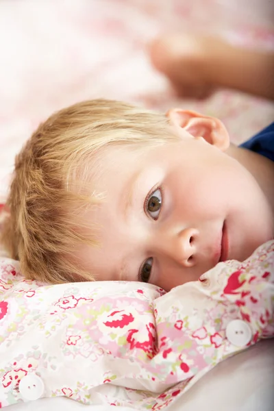 Jeune garçon se détendre sur le lit — Photo