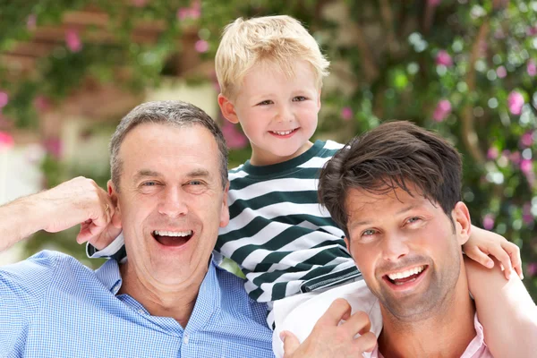 Abuelo y padre dando paseo nieto en hombros — Foto de Stock