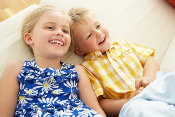 Zwei Kinder liegen kopfüber auf Sofa zu Hause — Stockfoto