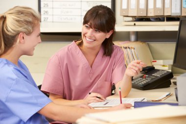 Two Nurses Working At Nurses Station clipart