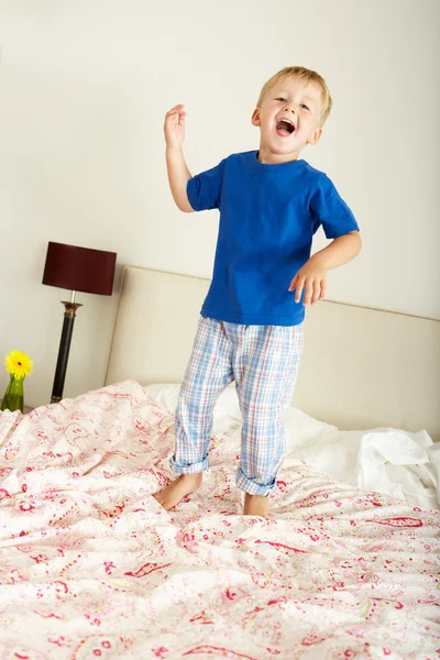 Jovem menino saltando em cama — Fotografia de Stock