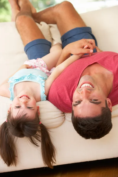 Vader ondersteboven liggend op de Bank met dochter — Stockfoto