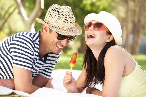 Pareja relajándose juntos en el jardín comiendo helado Lolly —  Fotos de Stock