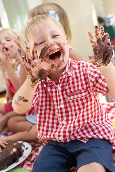 Group Of Children Eating Cake At Outdoor Tea Party — Stock Photo, Image