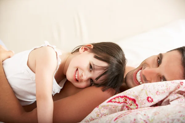 Vader en dochter ontspannen samen in bed — Stockfoto