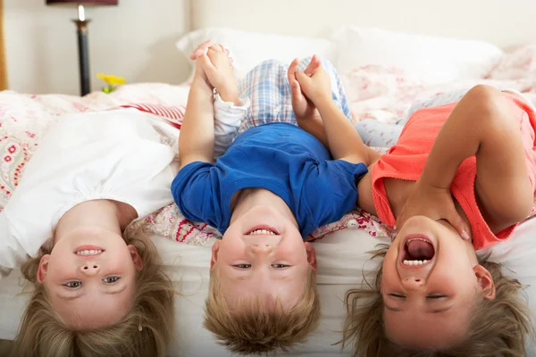 Kinder liegen kopfüber im Bett — Stockfoto