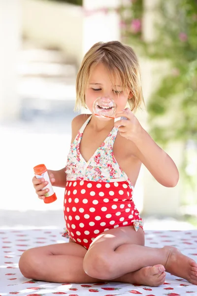 Ragazza che indossa costume da bagno che soffia bolle — Foto Stock