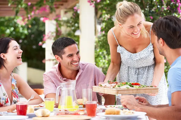 Grupo de amigos disfrutando de la comida al aire libre — Foto de Stock