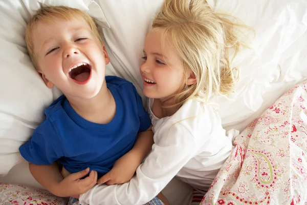 Broer en zus ontspannen samen in bed — Stockfoto