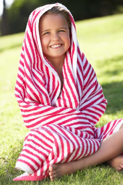 Ragazza avvolta in asciugamano seduto in giardino — Foto Stock