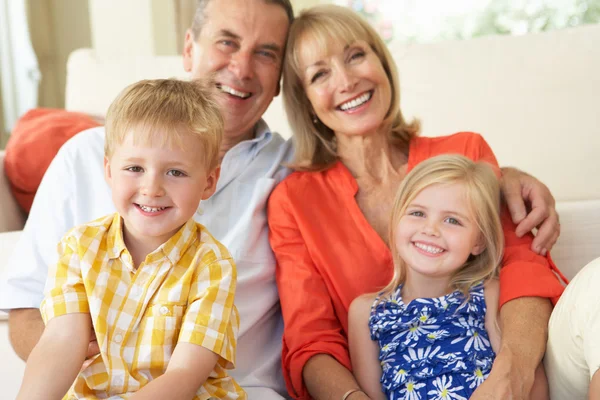 Grands-parents avec petits-enfants se détendre sur le canapé à la maison — Photo