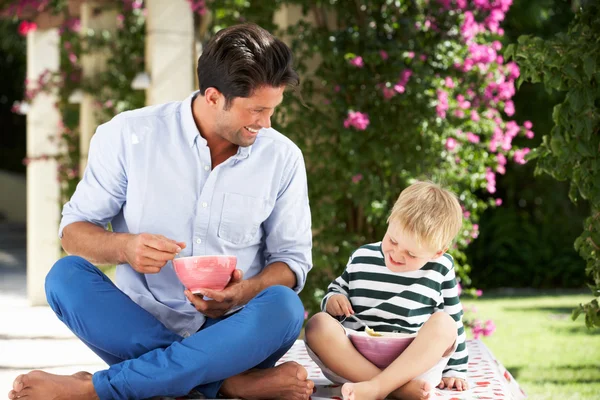 Padre e hijo disfrutando del desayuno cereales al aire libre juntos — Foto de Stock