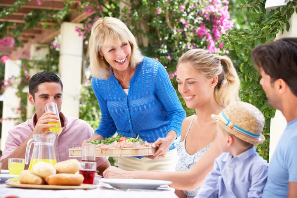 Senior vrouw serveren op multi generatie familie maaltijd — Stockfoto