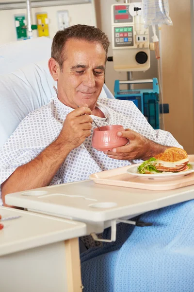 Mužský pacient užívat jídlo v nemocniční posteli — Stock fotografie