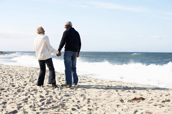 Casal sênior caminhando ao longo da praia juntos — Fotografia de Stock