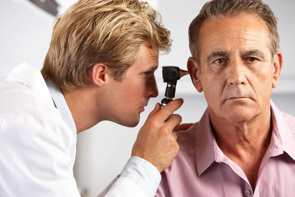 Doctor examinando las orejas de los pacientes masculinos — Foto de Stock