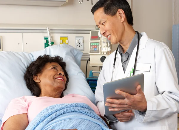 Médico usando tablet digital conversando com paciente sênior — Fotografia de Stock