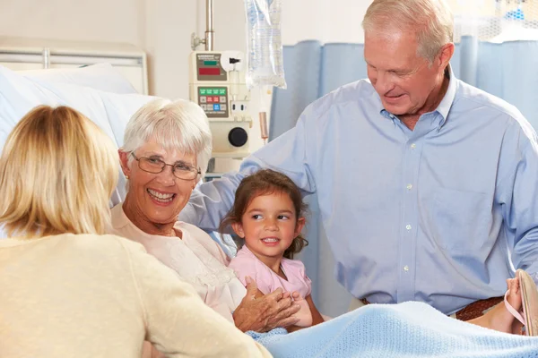 Familjen besöker äldre kvinnliga tålmodig i sjukhussäng — Stockfoto