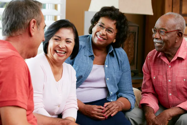 Groupe d'amis seniors bavarder à la maison ensemble — Photo