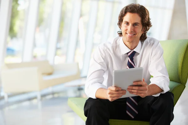 Businessman Sitting On Sofa In Office Using Digital Tablet — Stock Photo, Image