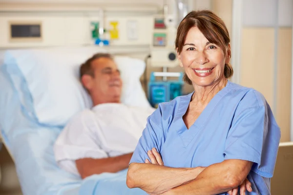 Porträtt av sjuksköterska med patienten i bakgrunden — Stockfoto