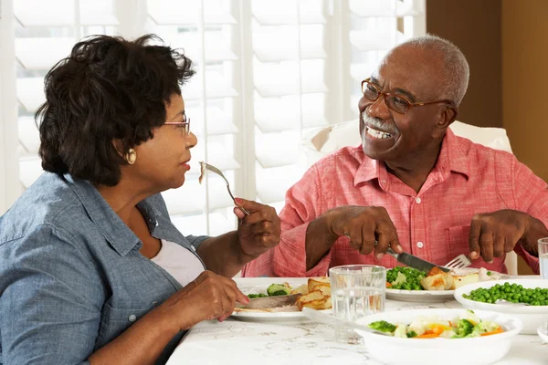 Pareja mayor disfrutando de la comida en casa — Foto de Stock