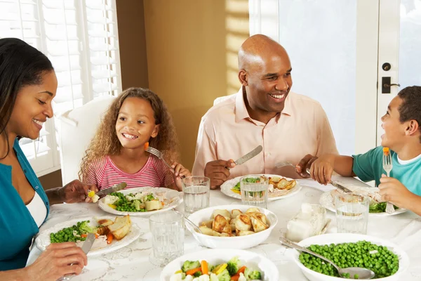 Familia disfrutando de la comida en casa —  Fotos de Stock