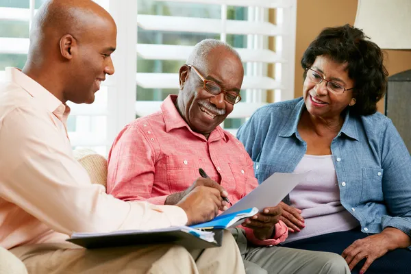 Finanzberater im Gespräch mit Senioren-Ehepaar zu Hause — Stockfoto