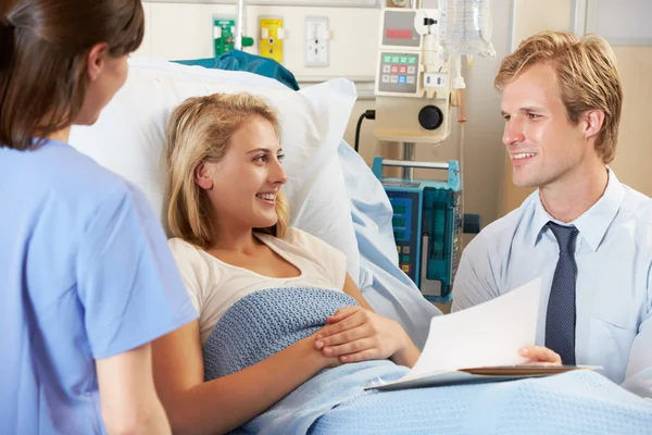 Médico com enfermeira conversando com paciente adolescente na cama — Fotografia de Stock