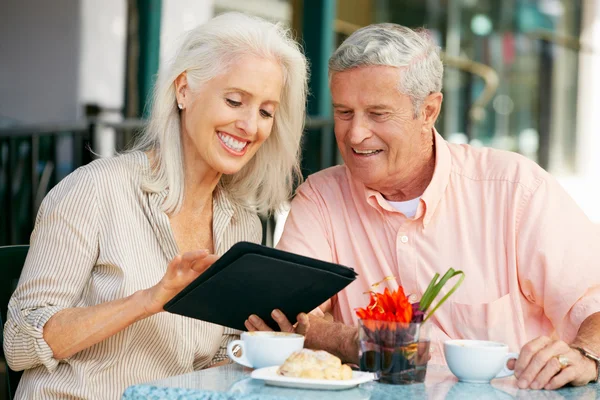 Senior vrouw genieten van snack in openlucht café — Stockfoto