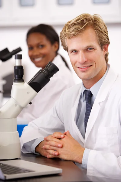 Scientifiques masculins et féminins utilisant des microscopes en laboratoire — Photo