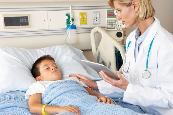 Médico usando bloco de notas digital enquanto visita paciente infantil — Fotografia de Stock