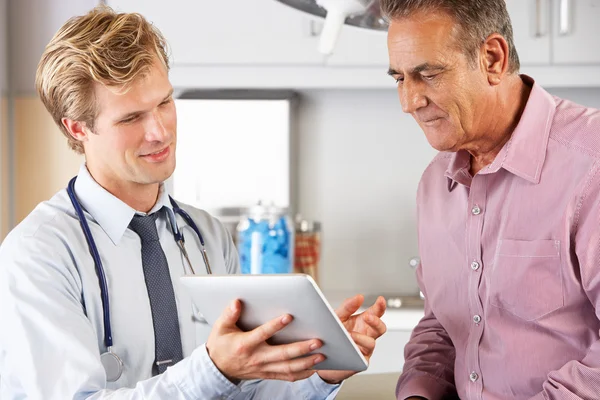 Médico discutindo registros com paciente usando tablet digital — Fotografia de Stock