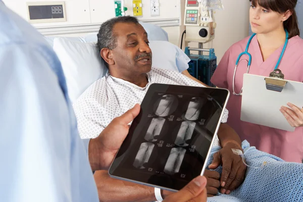 Doctor usando tableta digital en consulta con el paciente senior — Stockfoto