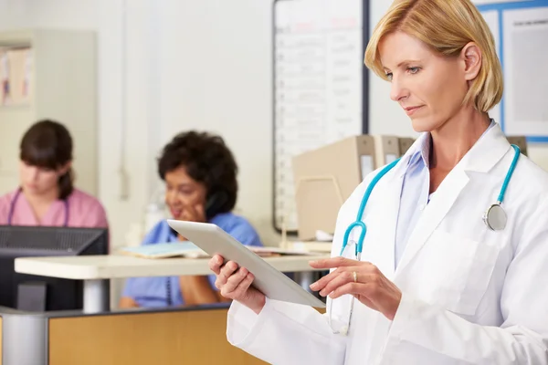 Médico femenino usando tableta digital en la estación de enfermeras —  Fotos de Stock