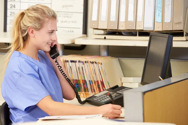 Nurse Making Phone Call At Nurses Station Royalty Free Stock Images