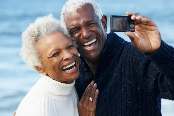 Senior koppel met camera op strand — Stockfoto