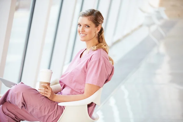Женщина-медсестра с помощью цифровой таблетки на перерыв кофе в больнице — стоковое фото