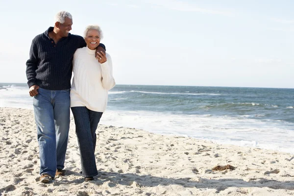Старшая пара прогуливаясь вдоль пляжа вместе — стоковое фото