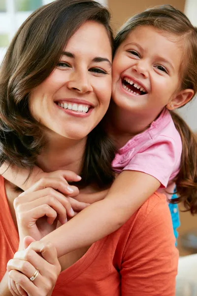 Retrato de la madre y la hija sentadas en el sofá en casa — Foto de Stock