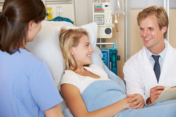 Arzt mit Krankenschwester im Gespräch mit Patientin im Bett — Stockfoto