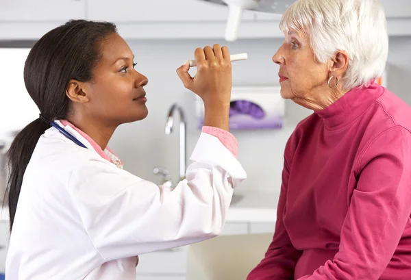 Médecin examinant les yeux d'une patiente âgée — Photo