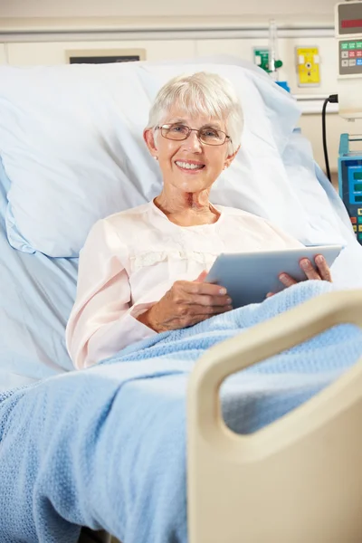 シニアの女性患者のデジタル タブルと病院のベッドでリラックス — ストック写真
