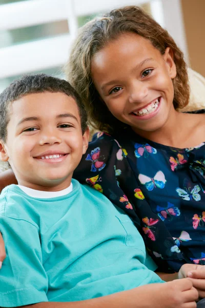 Retrato del hermano y la hermana sentados juntos en el sofá — Foto de Stock