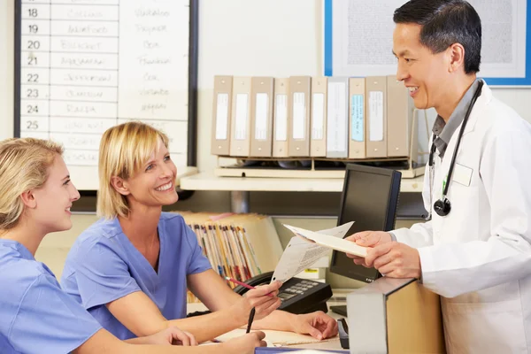 Médico con dos enfermeras trabajando en el puesto de enfermeras — Foto de Stock