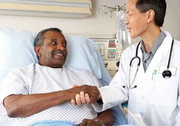Dokter bezoeken senior mannelijke patiënt op ward — Stockfoto