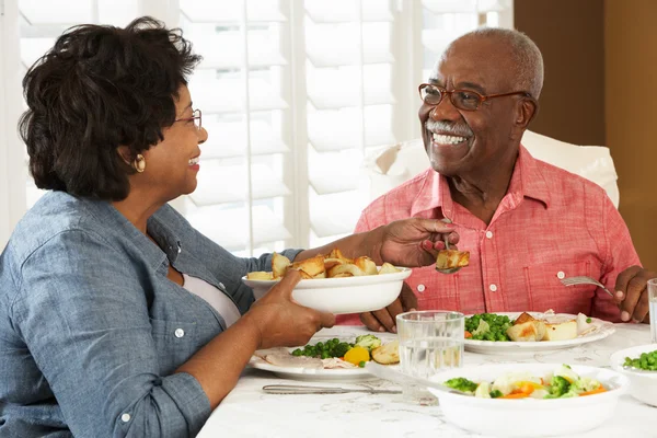 Pareja mayor disfrutando de la comida en casa — Foto de Stock