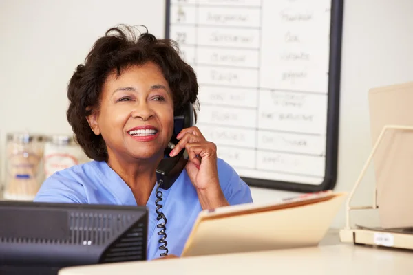 Nurse Making Phone Call At Nurses Station — Stock Photo, Image