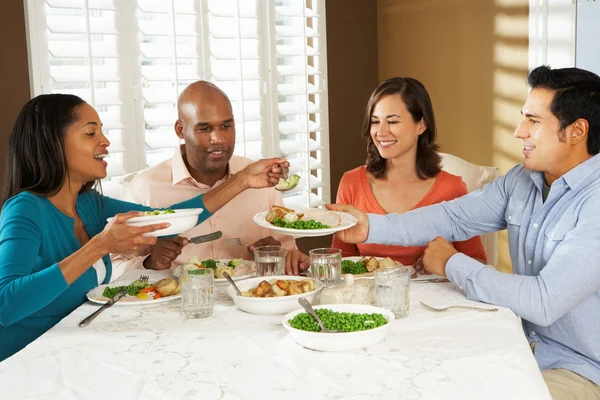 Grupo de amigos disfrutando de la comida en casa —  Fotos de Stock